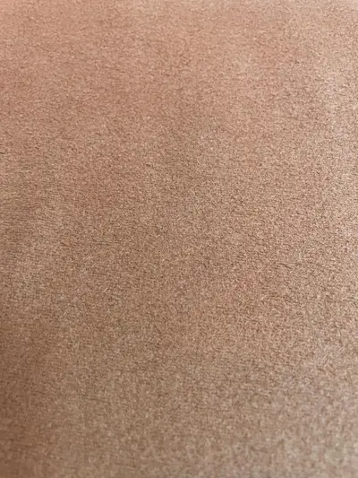 Nahaufnahme von fein strukturiertem Fleecestoff in Camel-Braun, weiche Mikrofleece-Oberfläche für Kleidung.