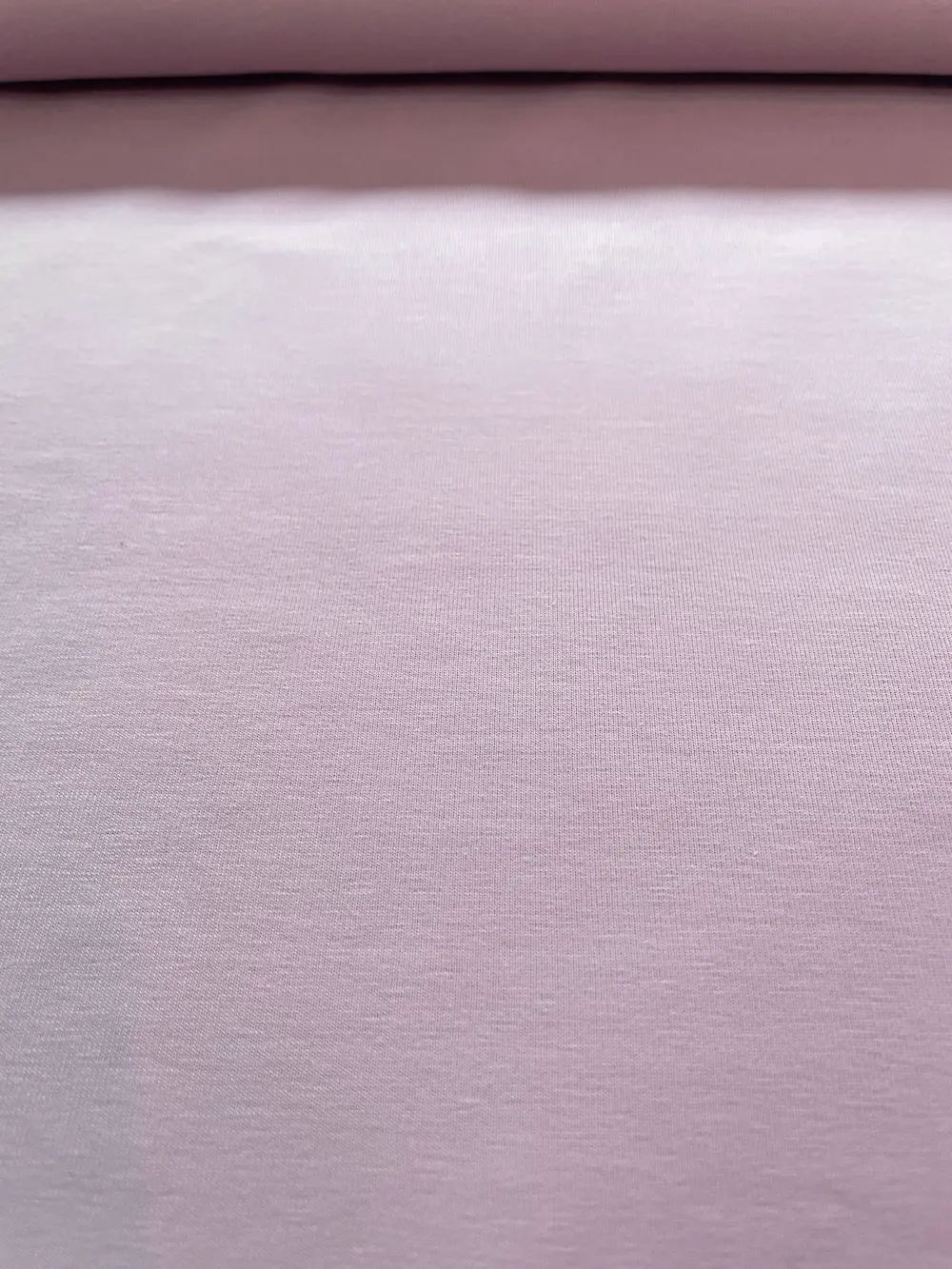 Nahaufnahme eines festen Baumwolljersey-Stoffs in Flieder-Mauve mit feiner Struktur, 220g Qualität.