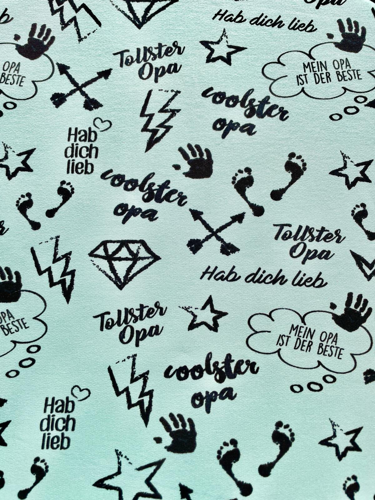 French Terry Stoff in Soft-Mint mit schwarzem Aufdruck 'Coolster Opa', 'Tollster Opa' und grafischen Motiven wie Blitzen und Sternen