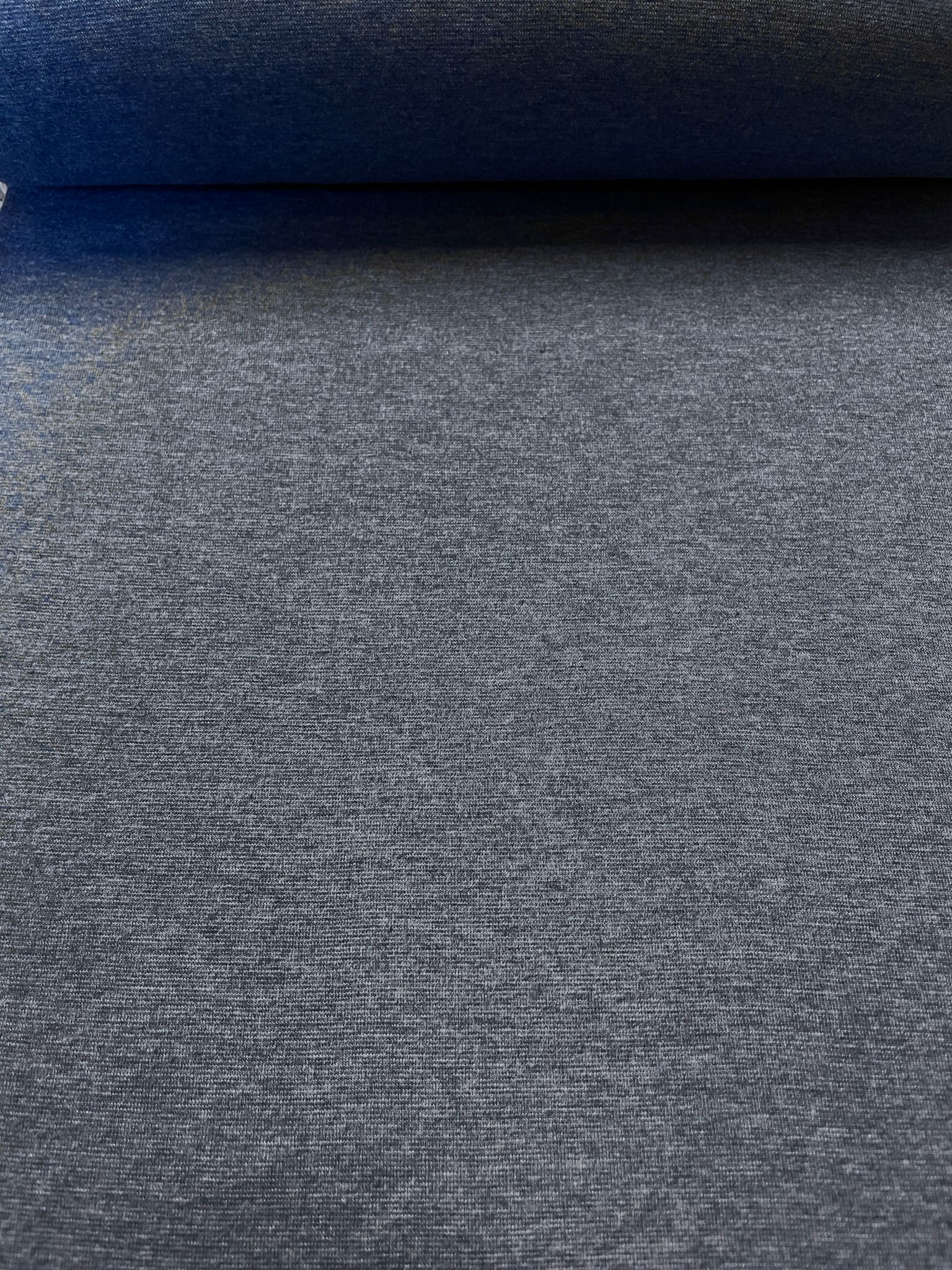 Nahaufnahme von einfarbigem (uni) Bündchenstoff in Schwarz als Meterware, feiner elastischer Strickstoff für Bekleidung.
