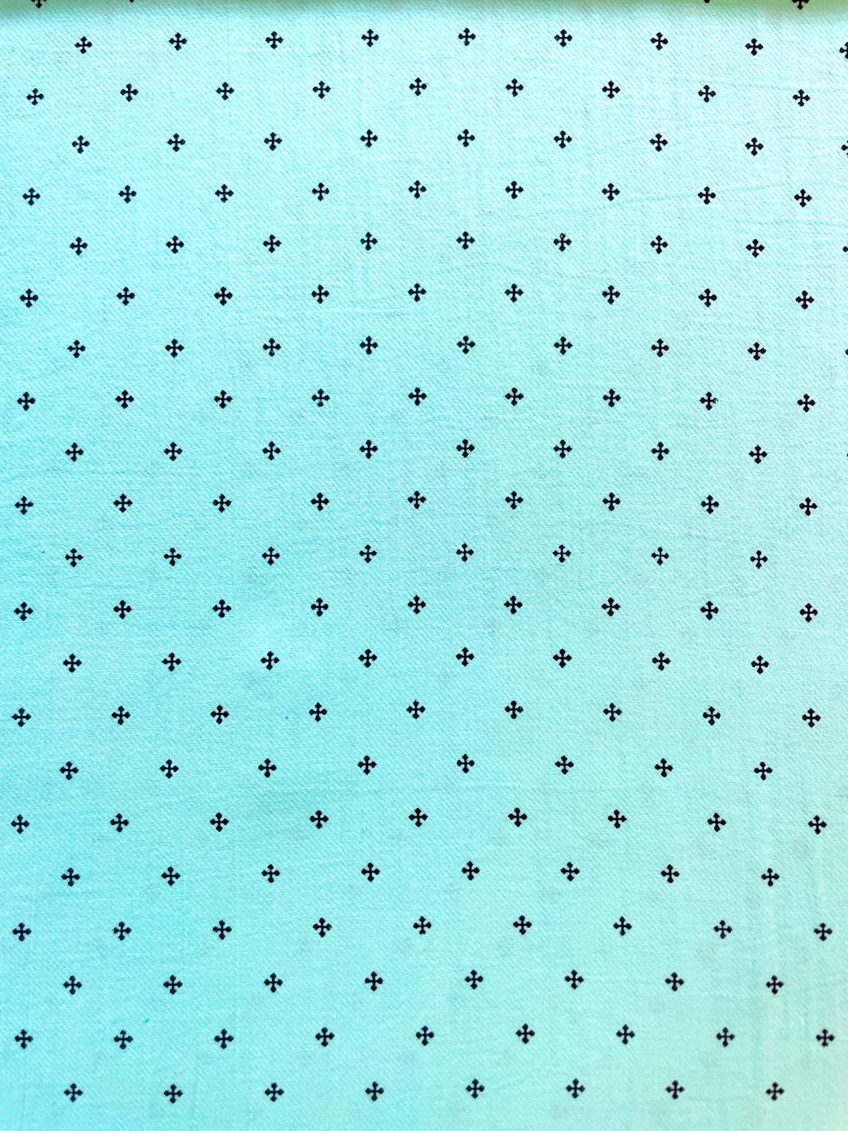 Detailaufnahme eines mintfarbenen Baumwoll-Musselins mit gleichmäßigem Muster aus kleinen schwarzen Rauten. Die typische weiche Double-Gauze-Struktur ist gut sichtbar.