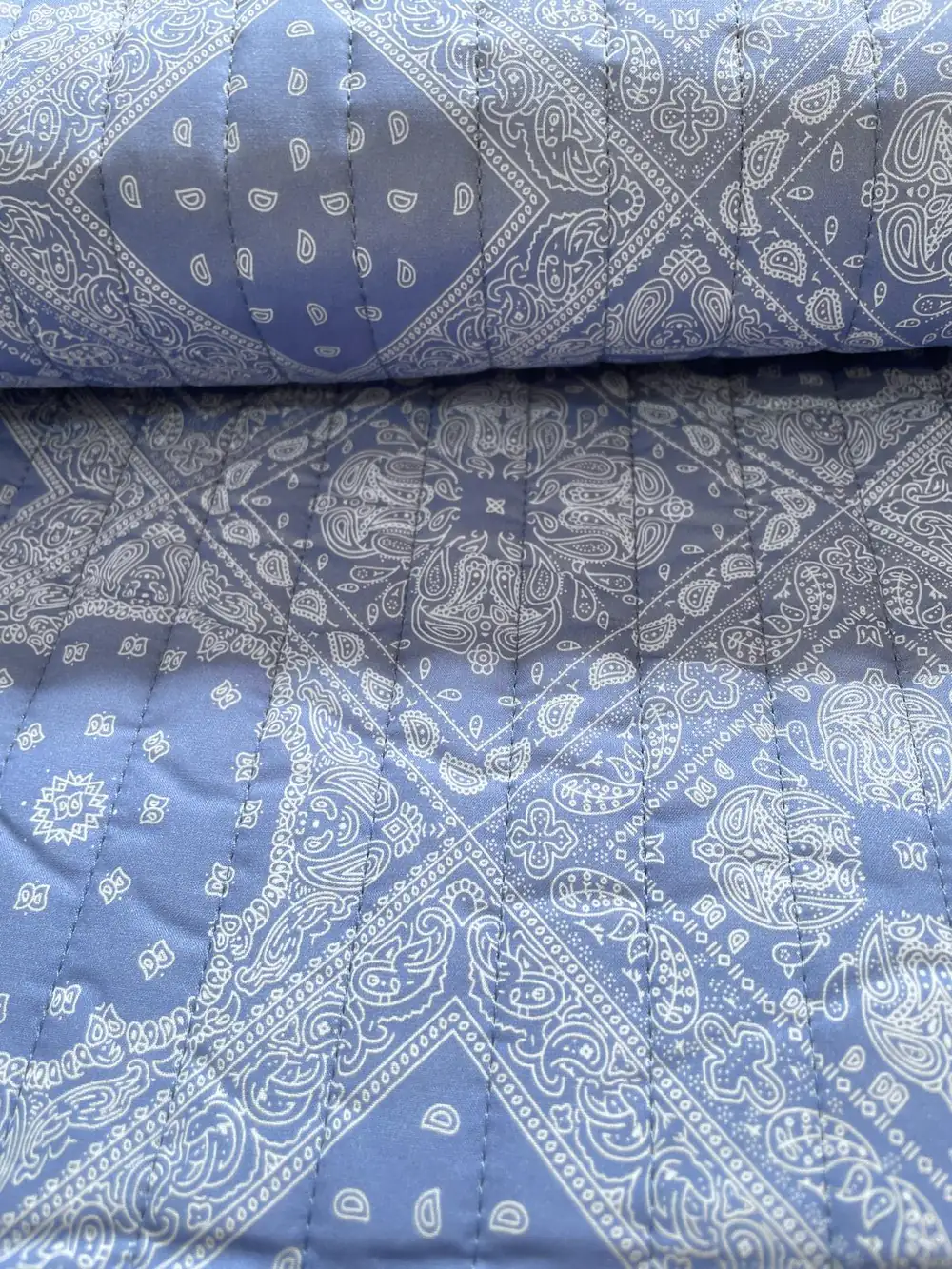 Hochwertiger, beidseitig verwendbarer Steppstoff als Meterware mit elegantem blauem Paisley-Muster, perfekt geeignet für wendbare Jacken und Wohnaccessoires.