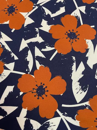 Hochwertiger French Terry Stoff mit großen abstrakten Blumen in Orange auf dunkelblauem Grund, weicher Sommersweat für Damen- und Kinderbekleidung.