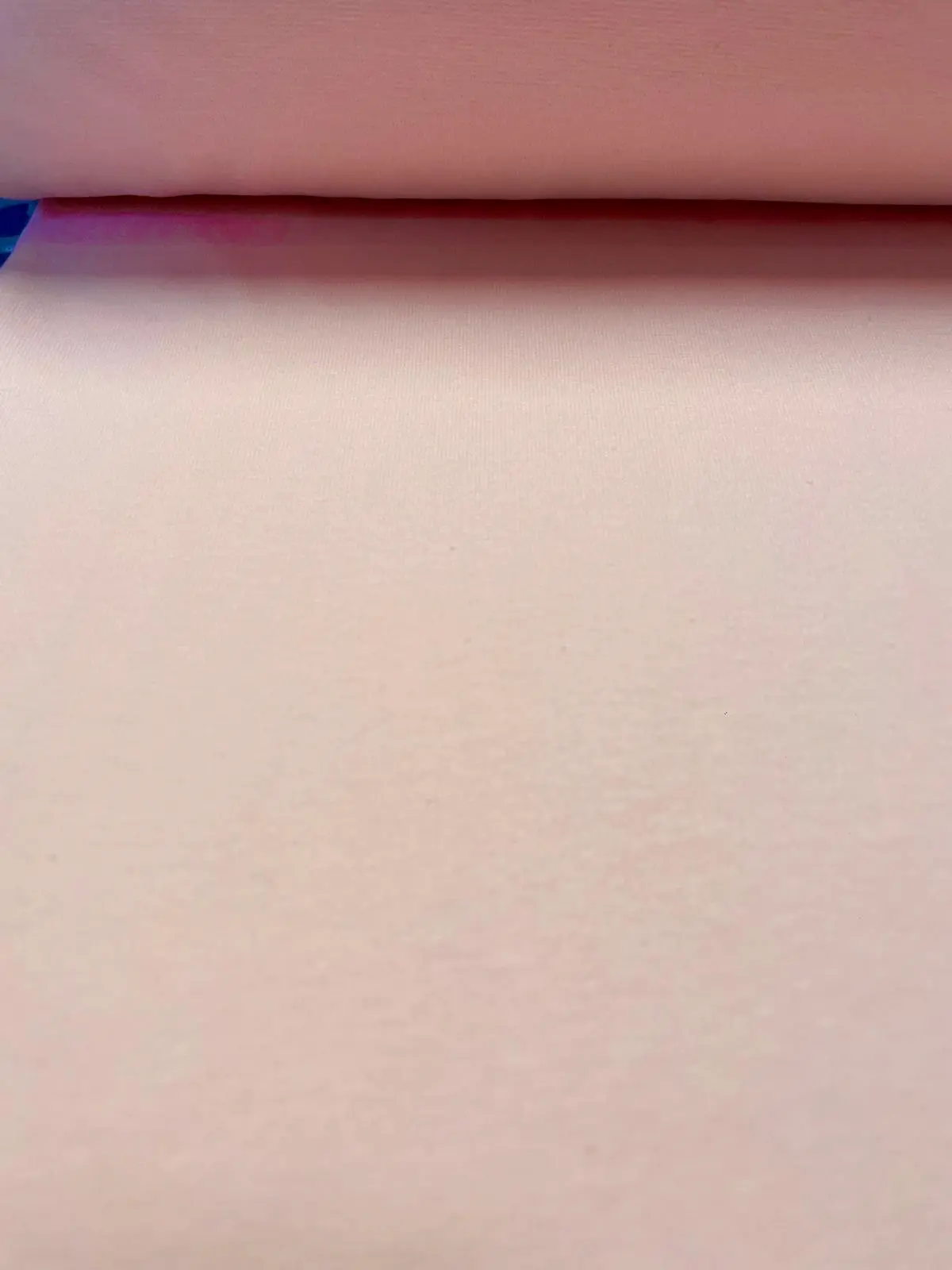 Nahaufnahme von elastischem Bündchenstoff in Hellpink als Meterware zum Nähen von Baby- und Kinderkleidung.