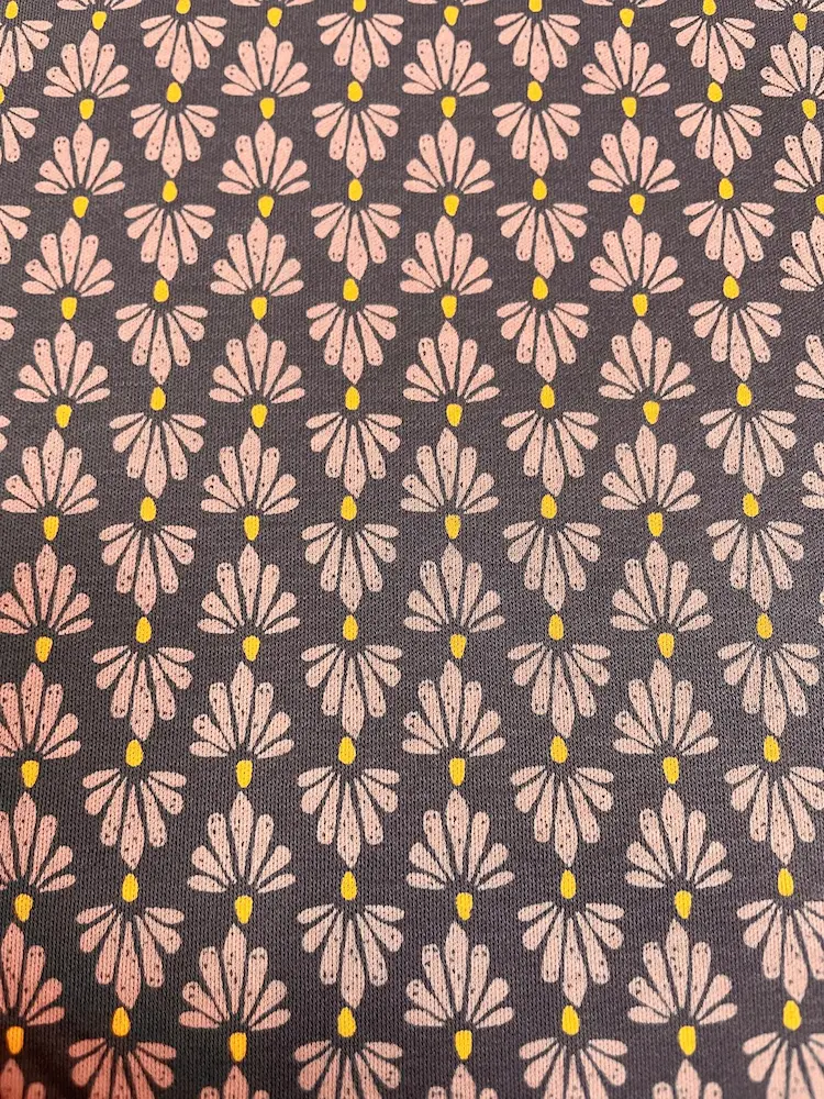 Detailansicht eines Jerseystoffs mit stilisiertem Fächer-Muster in Altrosa und Senfgelb auf dunkelgrauem Hintergrund im Art-Déco-Stil
