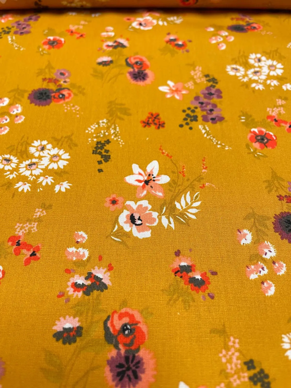 Hochwertige Baumwoll-Webware als Meterware in Senfgelb mit floralem Wildblumen-Muster kaufen. Ideal für herbstliche Kleider, Blusen & Deko. Jetzt bestellen!