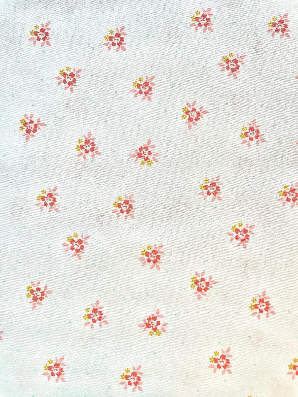 Weißer Baumwoll-Popeline Stoff mit kleinen, fein verteilten rosa und korallfarbenen Blüten, glattes Gewebe für leichte Sommerkleider und Kinderkleidung.