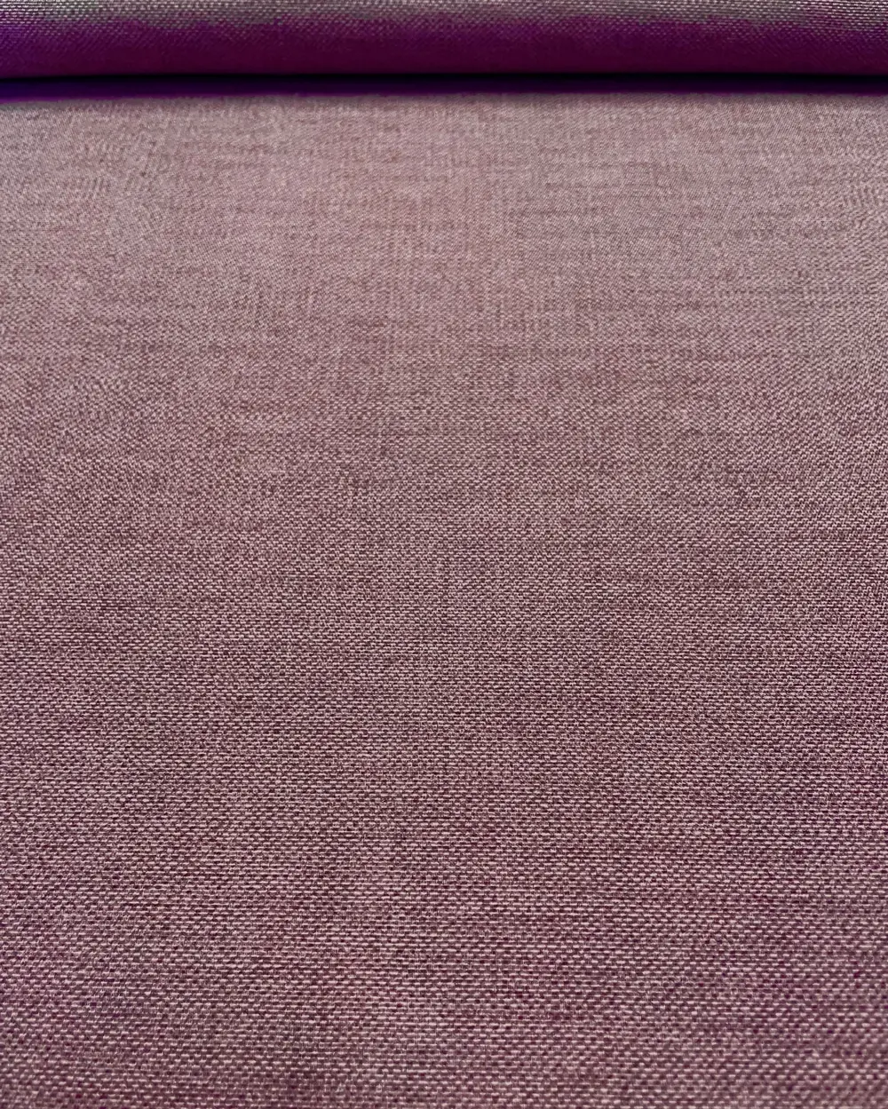 Nahaufnahme eines melierten Dekostoffs in gedecktem Mauve-Lila mit feiner Webstruktur aus Baumwolle und Polyester.