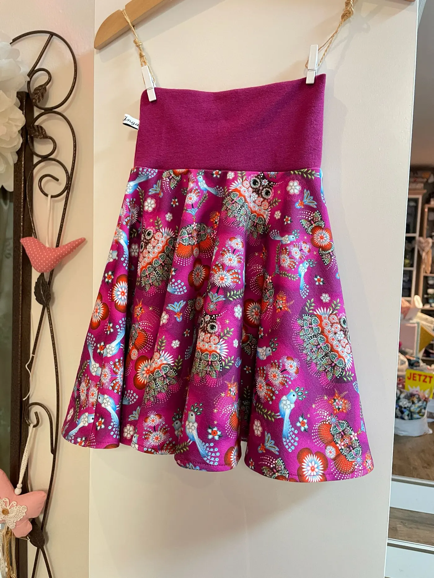 Handgenähter Kinderrock aus Jersey mit buntem Eulen-Folklore-Muster in Magenta. Ausgestellter Rock mit breitem elastischem Bündchen, präsentiert an einem Kleiderbügel