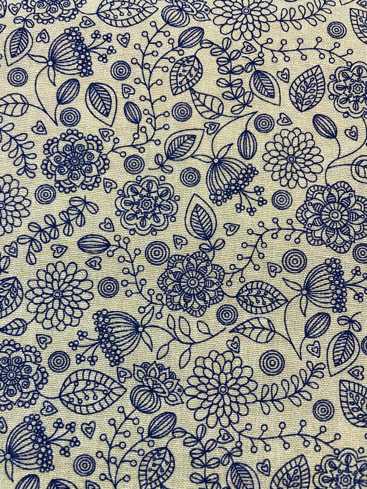 Strukturierter Canvas Dekostoff als Meterware in Natur-Beige mit einem feinen, dunkelblauen Linienmuster aus Blumen, Ranken und kleinen Herzen.