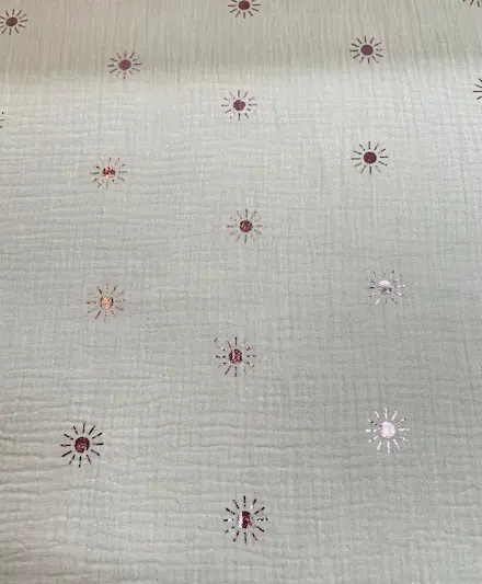 Weicher Musselin-Stoff in Hellrosa mit glitzernden Sonnen-Motiven in Kupfer-Optik, Double Gauze Baumwollstoff für Mädchen-Kleidung und Baby-Accessoires.