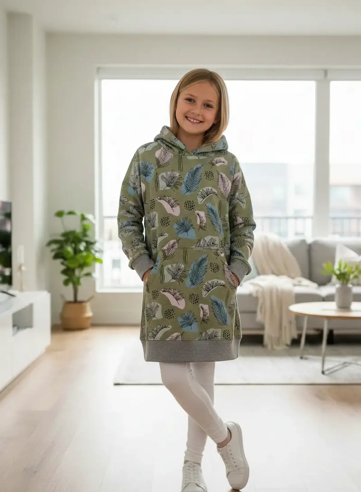 French Terry Meterware mit Blätter-Print in Oliv, Blau und Rosa, verarbeitet als Kinder-Hoodie-Kleid.