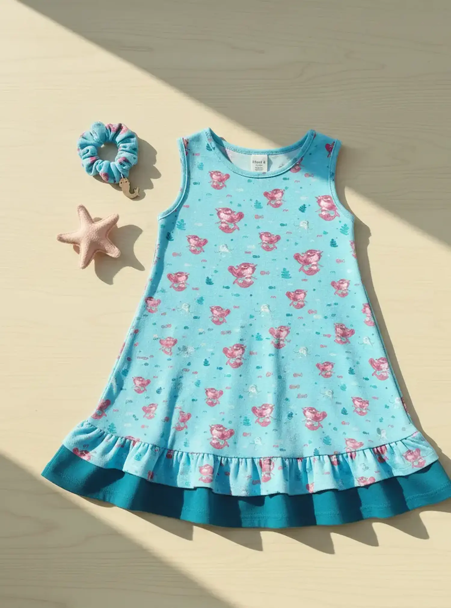 Nahaufnahme von hellgrauem Baumwolljersey als Meterware mit einem Allover-Print aus niedlichen grünen Schildkröten, die einen kleinen Blumenkranz auf dem Kopf tragen, umgeben von kleinen dunklen Blüten.