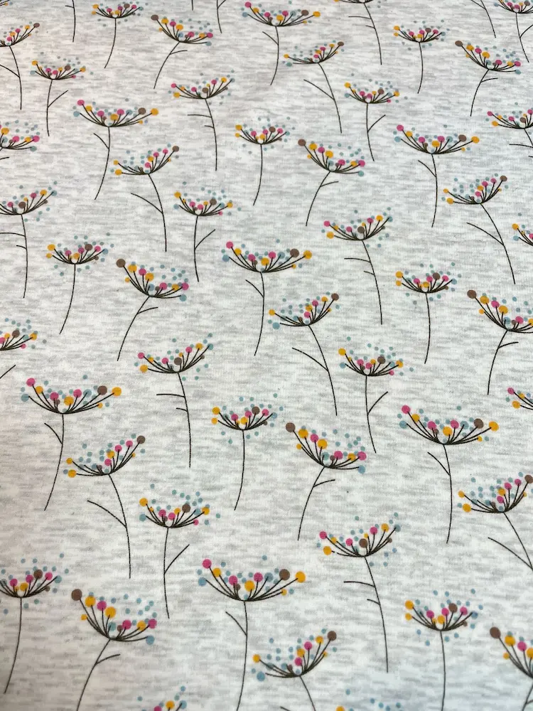 Weicher Alpenfleece-Stoff als Meterware in Hellgrau-Melange mit einem minimalistischen Muster aus filigranen Doldenblüten und bunten Punkten in Pink, Blau und Senfgelb.