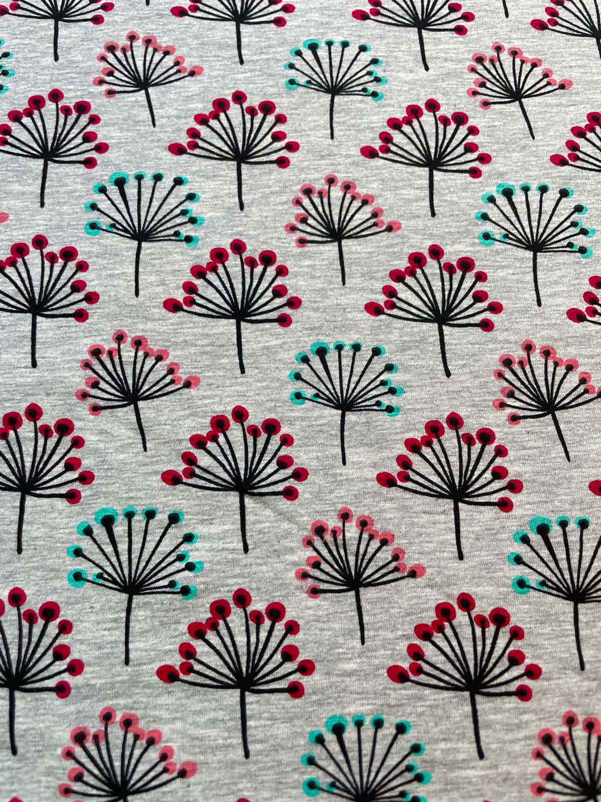 Elastischer Baumwolljersey als Meterware in Grau-Meliert, bedruckt mit einem modernen, skandinavischen Muster aus schwarzen Doldenblüten und Pusteblumen mit Punkten in Beere, Rosa und Türkis.
