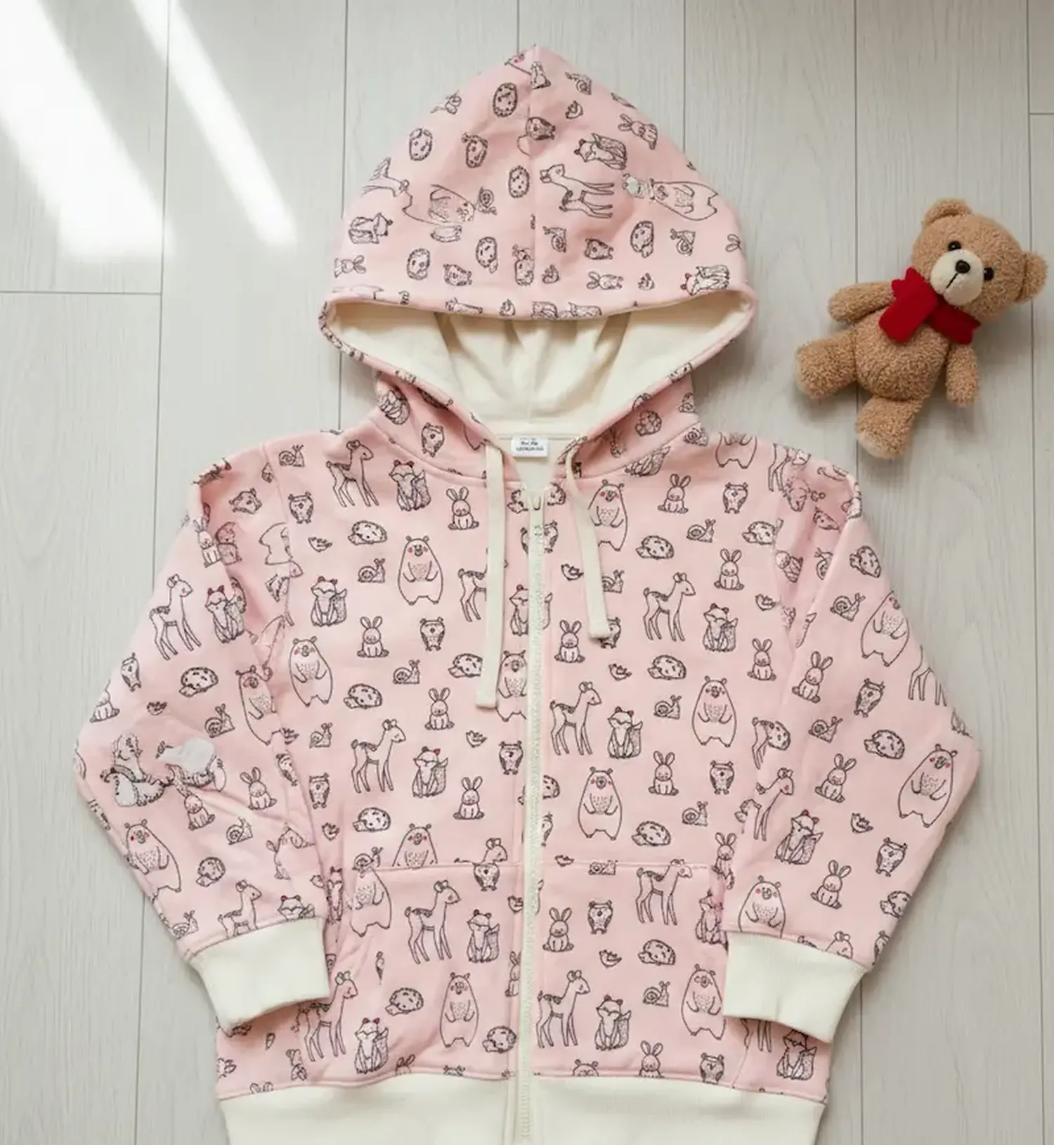 Selbstgenähte Kinder-Kapuzenjacke aus rosa French Terry mit Waldtier-Print, Reißverschluss und cremefarbenen Bündchen – Nähidee für Sommersweat.