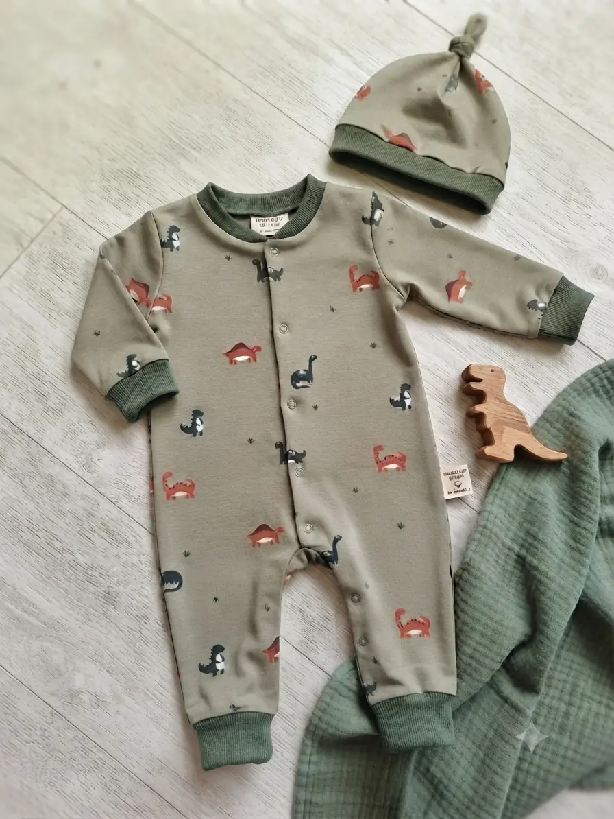 Baumwolljersey Stoff mit Dinosaurier-Print in olivgrün, ideal für Babybekleidung.
