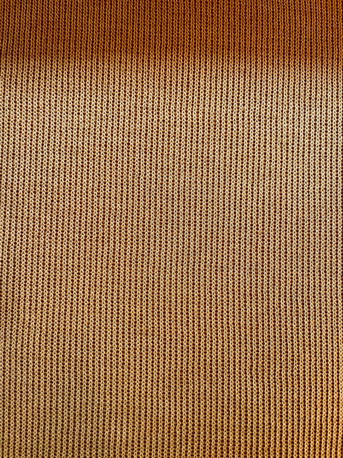 Elastischer Feinstrick-Jersey als Meterware in warmem Ockergelb mit einer feinen, gleichmäßigen Strickstruktur.