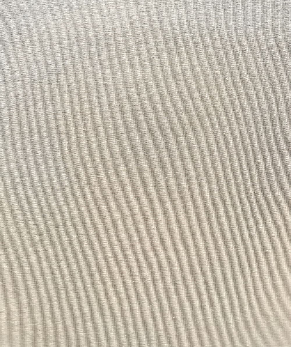 Glatter, uni-farbener Jersey-Stoff in hellem Sand-Beige aus Baumwolle mit Elasthan für hochwertige Bekleidung.