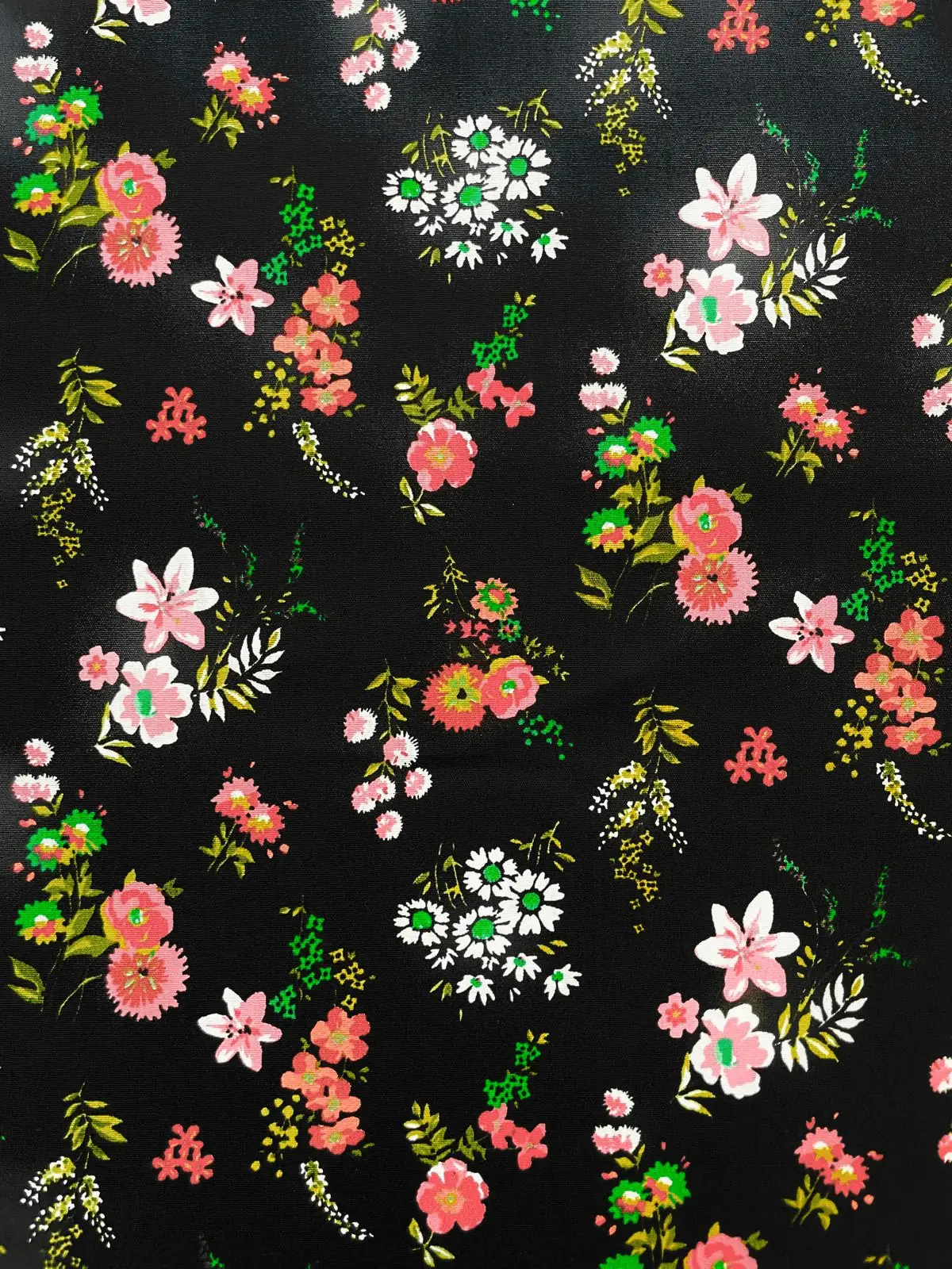 Schwarzer Baumwollstoff Webware mit buntem Blumenmuster aus Rosen und Gänseblümchen, glatte Textur für Kleidung und Dekoration.