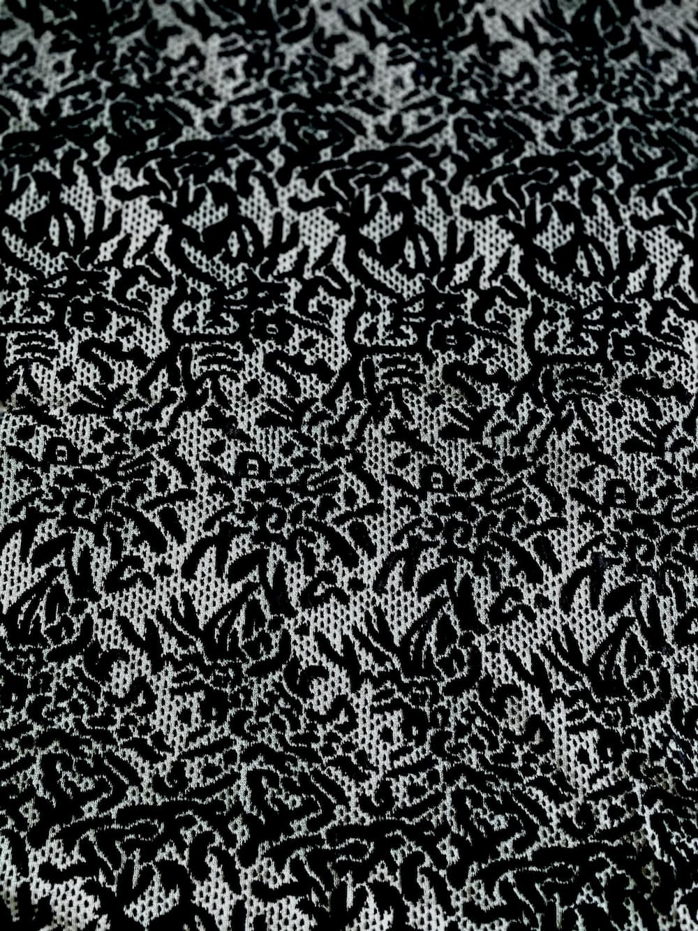 Eleganter Spitzen-Jersey als Meterware mit schwarz-weißem Muster und feiner Struktur für Kleider und Oberteile.