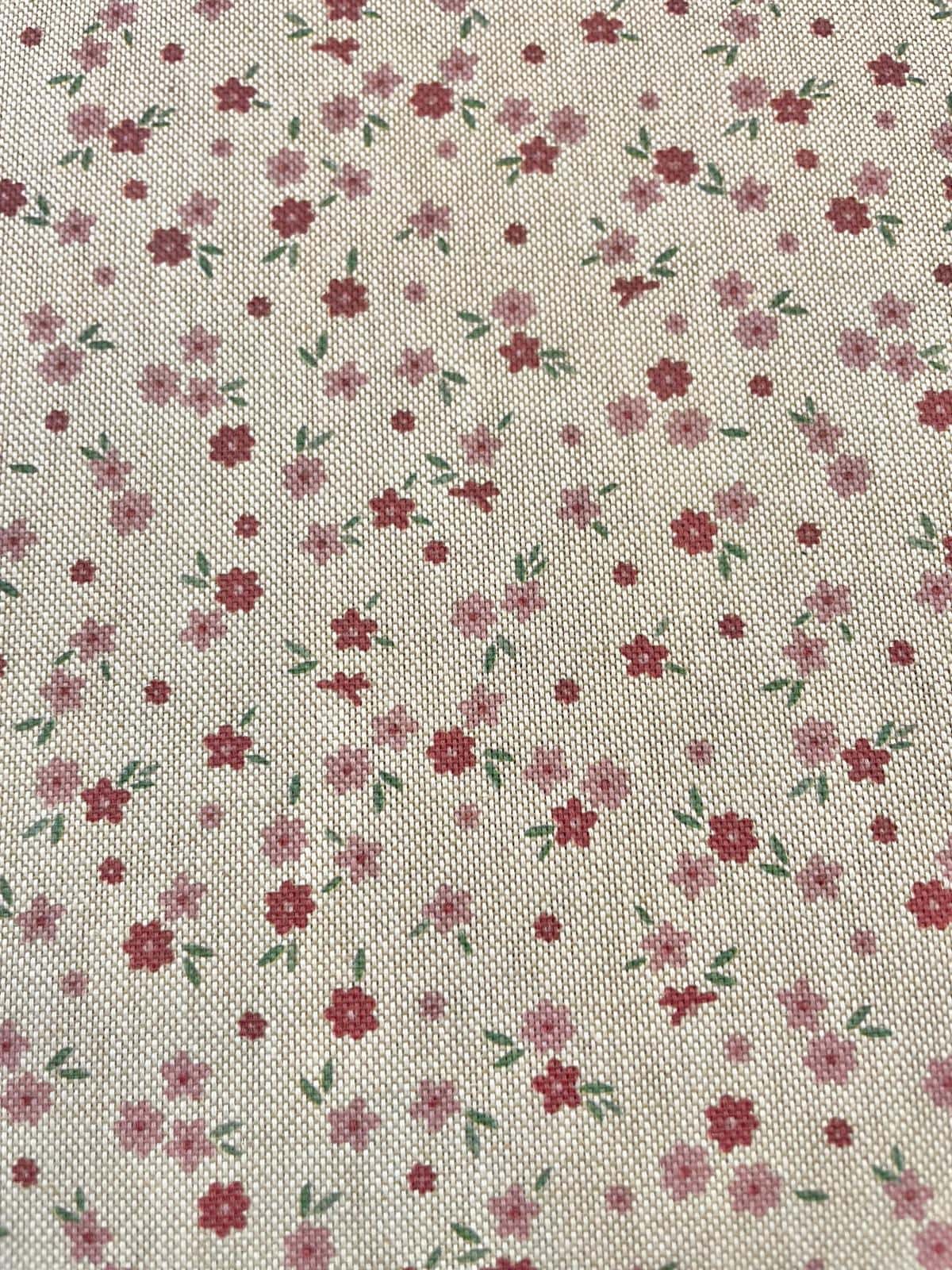 Strukturierter Dekostoff als Meterware mit kleinen, zarten Streublümchen in Rosa und Rot auf hellem Hintergrund in Leinenoptik.