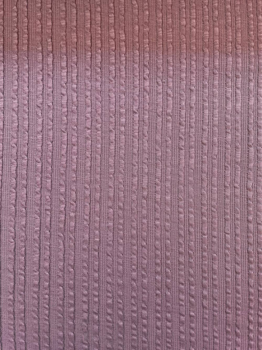 Hochwertiger Baumwolljersey in Mauve mit vertikaler Zopfstrick-Struktur, weiche Haptik für Kinderkleidung und Accessoires.