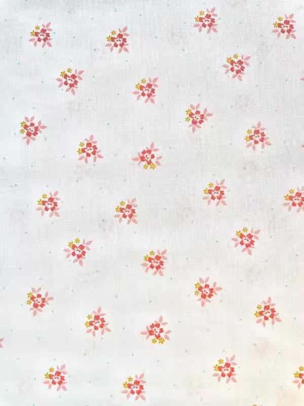Weißer Baumwoll-Popeline Stoff mit kleinen, fein verteilten rosa und korallfarbenen Blüten, glattes Gewebe für leichte Sommerkleider und Kinderkleidung.