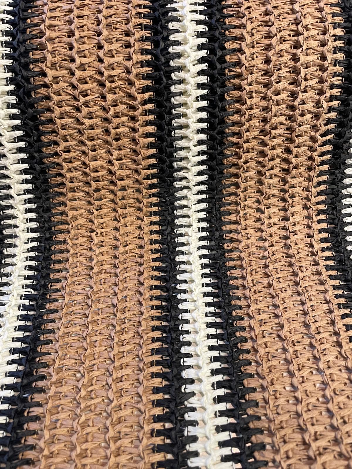 Grob gewebter Taschenstoff in Bast-Optik mit vertikalem Streifenmuster in Schwarz, Beige und Naturbraun, Raffia-Häkel-Stil.
