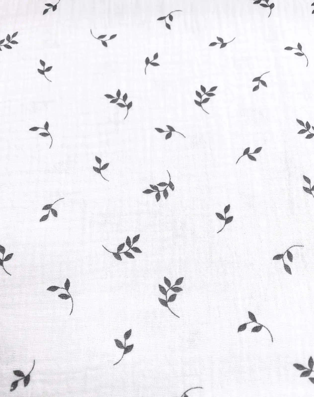 Weißer Musselin-Stoff aus Baumwolle mit feinem schwarzen Blätter-Print, Double Gauze Qualität für Halstücher und Baby-Textilien.