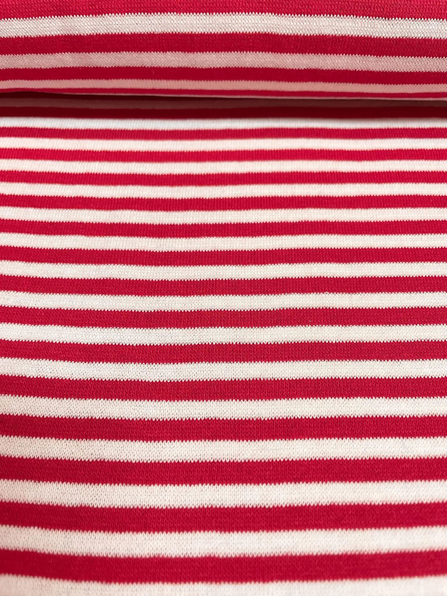 Gestreifter Bündchenstoff in Rot und Weiß als elastische Schlauchware (Meterware) für Pulloverbündchen und Kindermode.