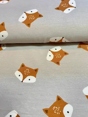 Weicher French Terry Stoff in Grau mit großen Fuchsköpfen in Orange, elastischer Sommersweat als Meterware für Kinderpullover.