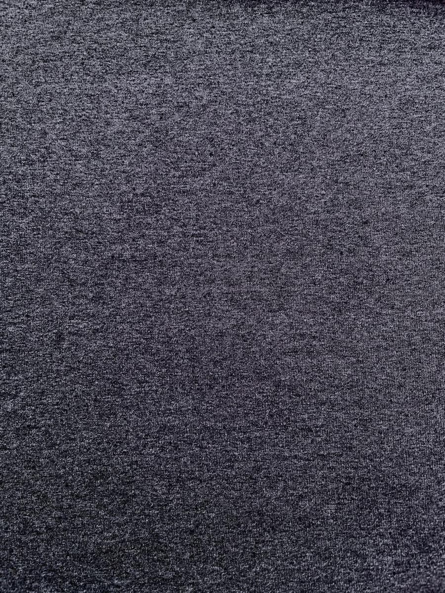 Nahaufnahme der melierten Oberflächenstruktur eines nachhaltigen Jersey-Stoffes in Anthrazit aus recycelter Baumwolle und Polyester.