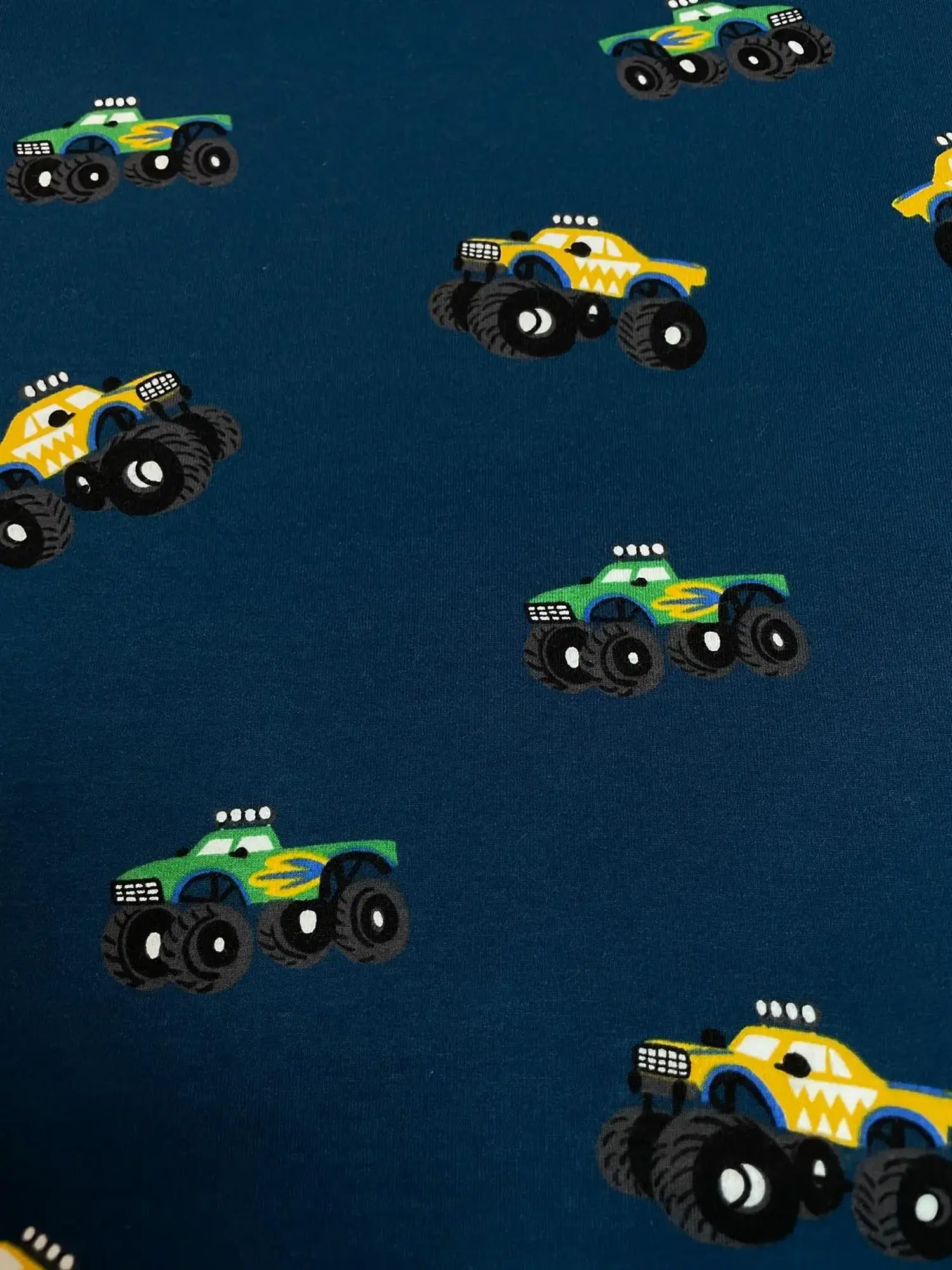 Angerauter Sweat Stoff in Navy Blau mit bunten Monstertrucks, weiche Innenseite, Meterware für Kinderpullover.