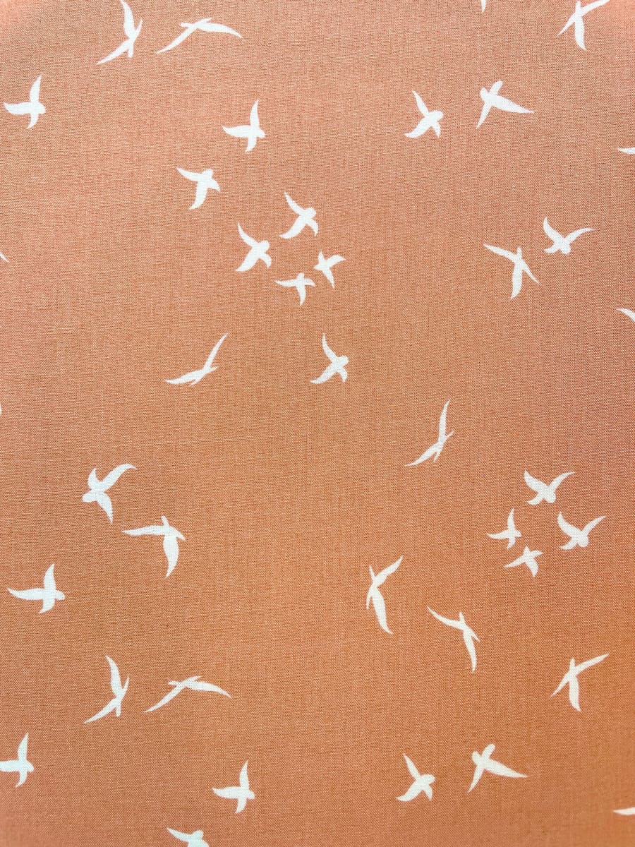 Weich fließender Viskose-Webstoff in Terrakotta mit weißem Vogel-Print; Meterware für sommerliche Bekleidung.