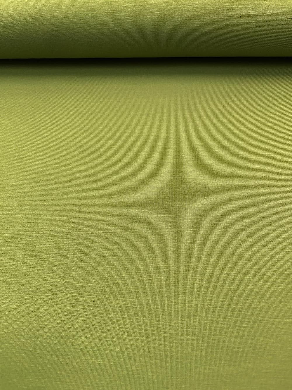 Nahaufnahme von moosgrünem Jersey-Stoff aus 95% Baumwolle und 5% Elasthan mit feiner Textur und satter Farbe.