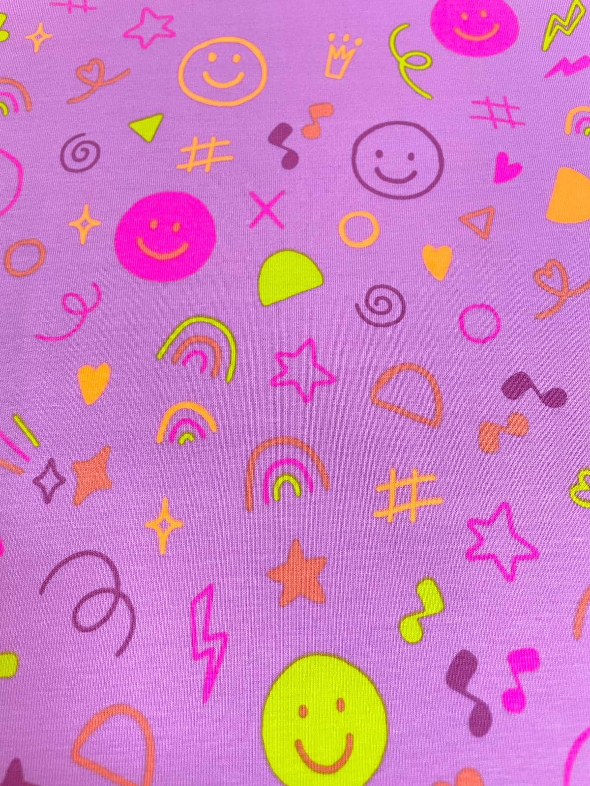 Elastischer Jersey-Stoff in Flieder mit bunten Neon-Motiven: Smileys, Regenbögen, Sterne und Musiknoten im modernen Doodle-Stil. Farbenfroher Kinderstoff für T-Shirts und Accessoires.