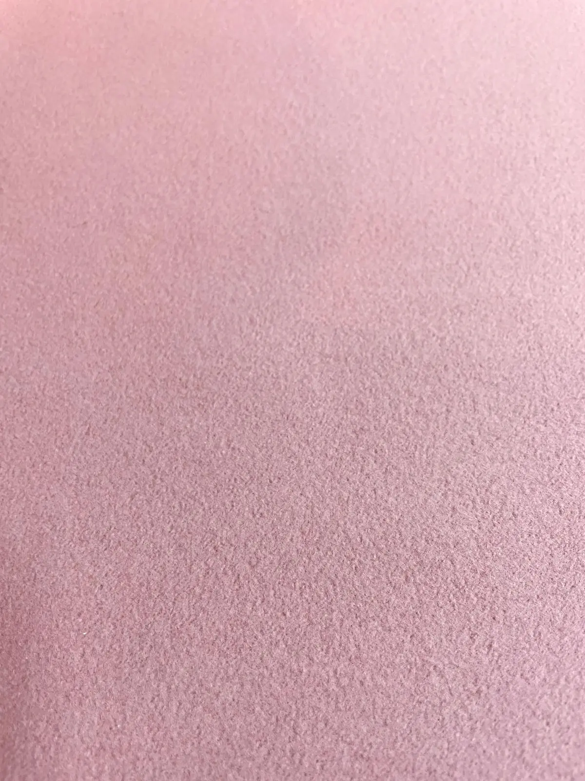 Nahaufnahme von weichem Baumwollfleece in Altrosa, natürliche matte Textur für schadstofffreie Babybekleidung.