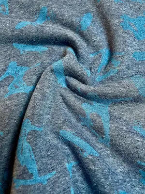 Warmer Alpenfleece Stoff in Jeansblau Melange mit türkisen Skater-Motiven, weich gefütterter Kuschelsweat für Kinder, Meterware.