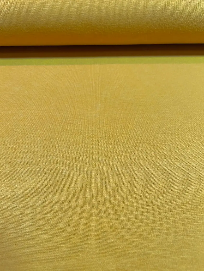 Nahaufnahme von Alpenfleece-Stoff als Meterware in der Farbe Senfgelb mit feiner Oberflächenstruktur