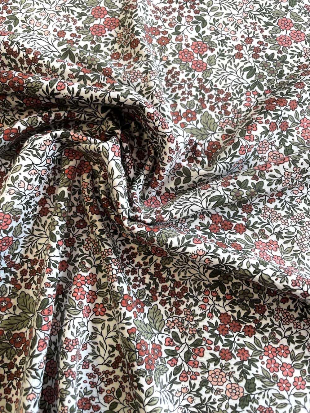 Elastischer Baumwoll-Jersey-Stoff als Meterware mit einem detailreichen Kleinblumen-Print in Altrosa, Weiß und Olivgrün