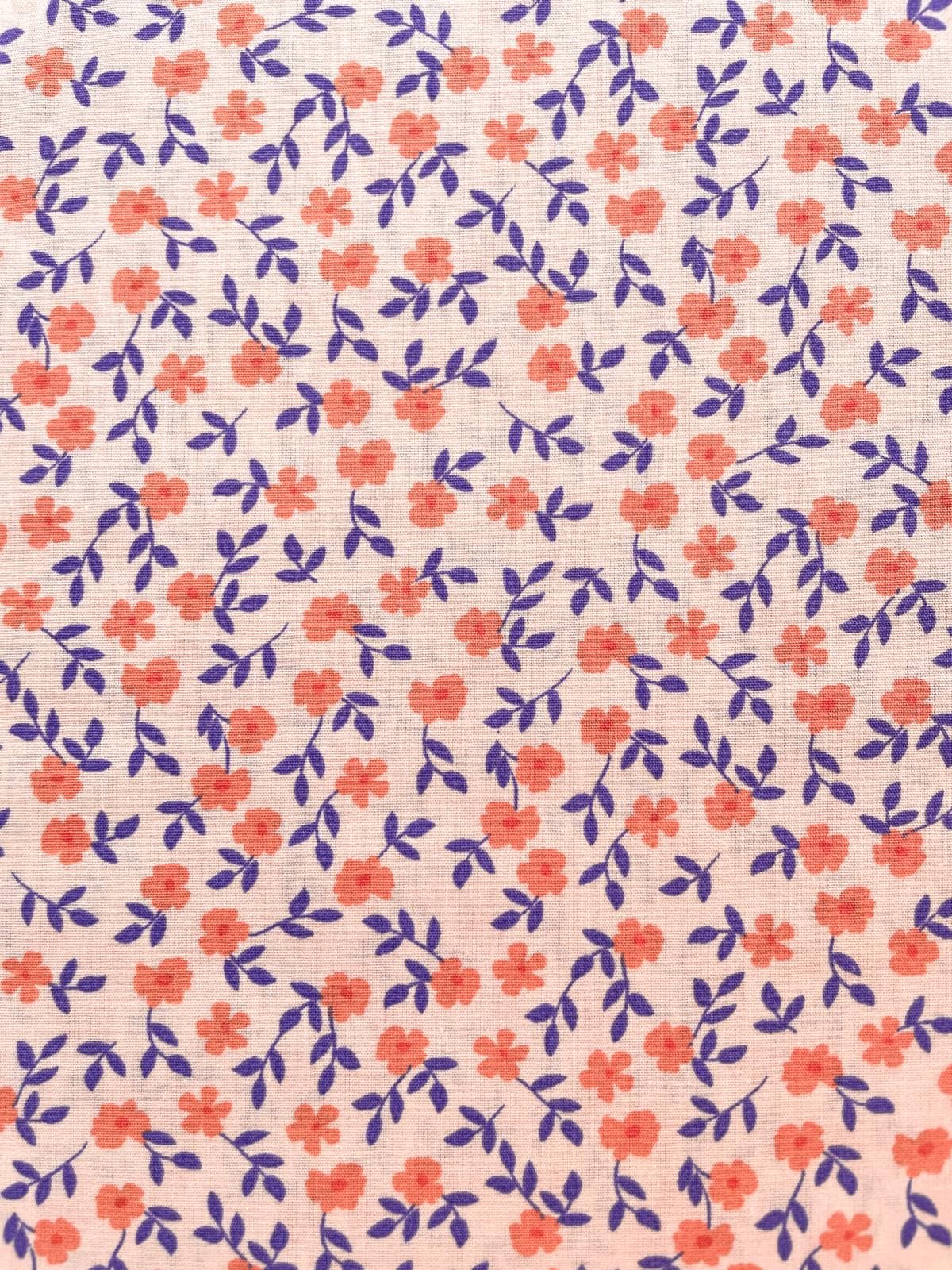 Nachhaltiger Bio-Baumwollstoff mit feinem Blumenmuster in Apricot und Violett auf hellem Grund, 135g schwere Popeline-Qualität.