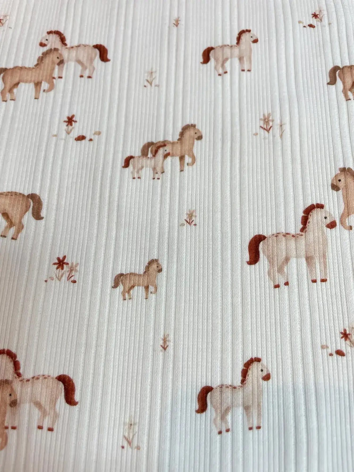 Feiner Rippjersey Stoff in Creme mit kleinen Pferden und Ponys, elastischer Rippstrick für Babykleidung, hautfreundliche Meterware.