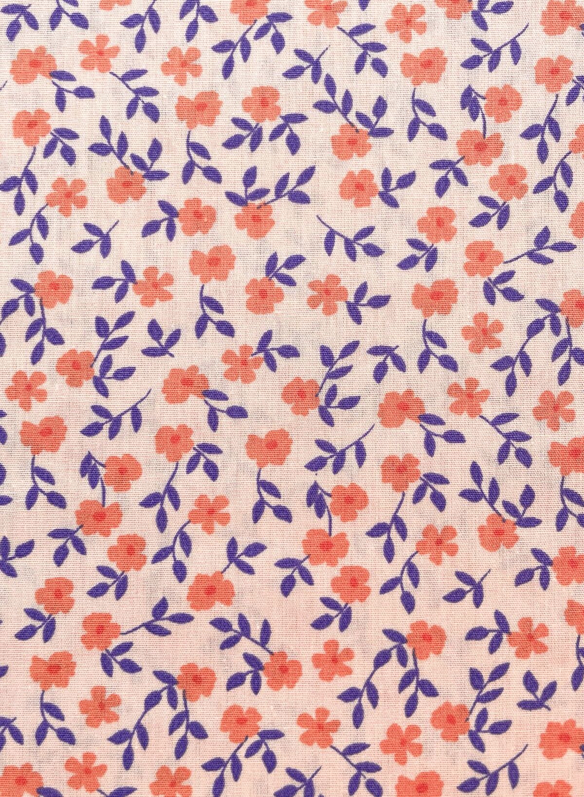 Nachhaltiger Bio-Baumwollstoff mit feinem Blumenmuster in Apricot und Violett auf hellem Grund, 135g schwere Popeline-Qualität.