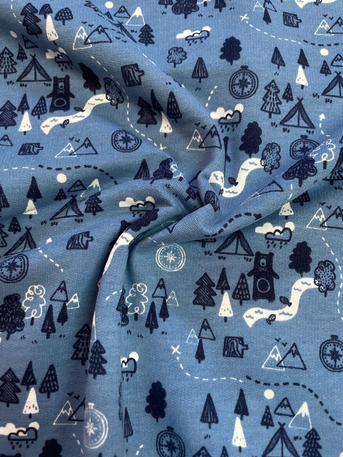 Blauer Sommersweat Stoff mit Bären, Bergen und Wanderkarten-Motiv, weich angeraute Innenseite, elastische Meterware für Kinderhoodies.