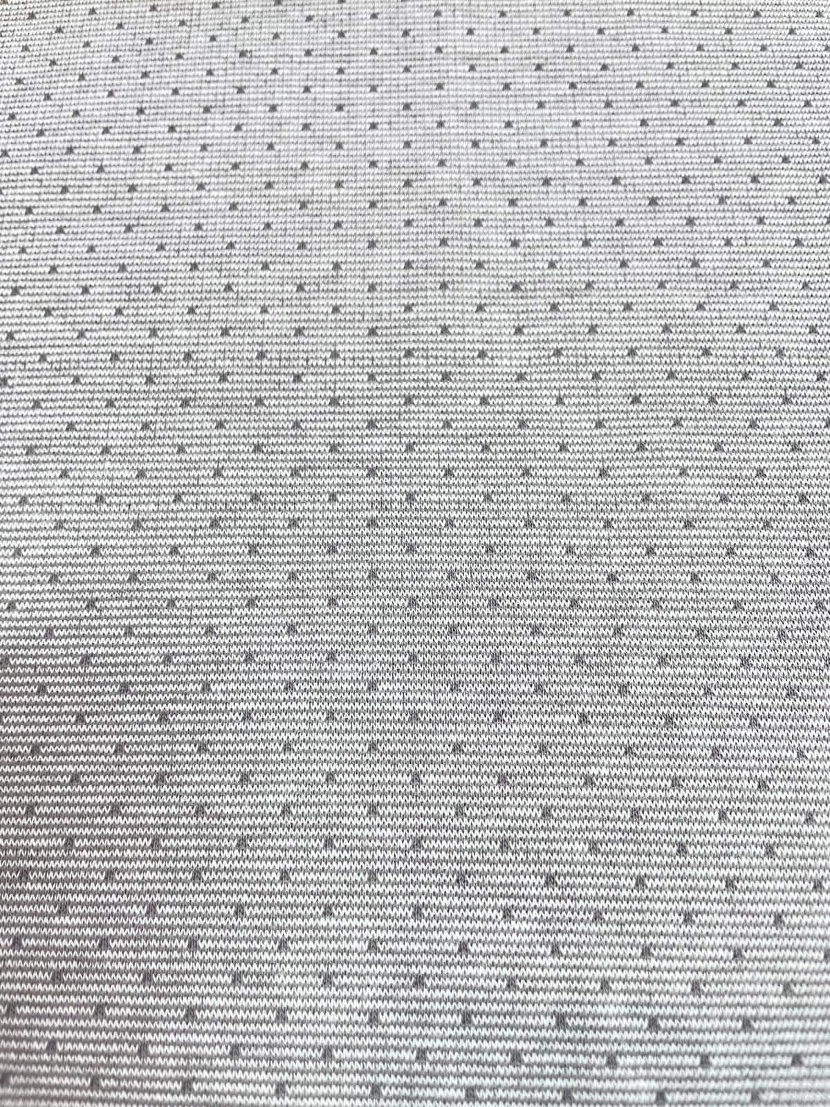 Nachhaltiger Bio-Jacquard-Strickstoff in hellem Grau mit einem gleichmäßigen, feinen Punktemuster in Weiß. Die hochwertige Strickstruktur ist im Detail erkennbar. Der blickdichte und weiche Stoff aus Bio-Baumwolle eignet sich perfekt für minimalistische D