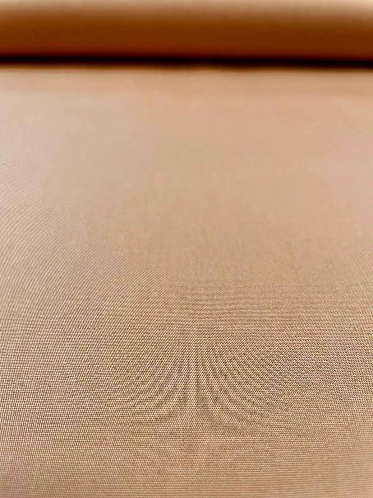 Nahaufnahme der Struktur von Baumwoll-Popeline Stoff in Camel-Beige als Meterware