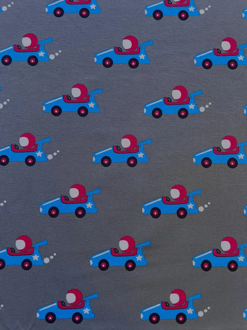 Mittelgrauer Jersey-Stoff bedruckt mit kleinen roten und blauen Rennwagen.