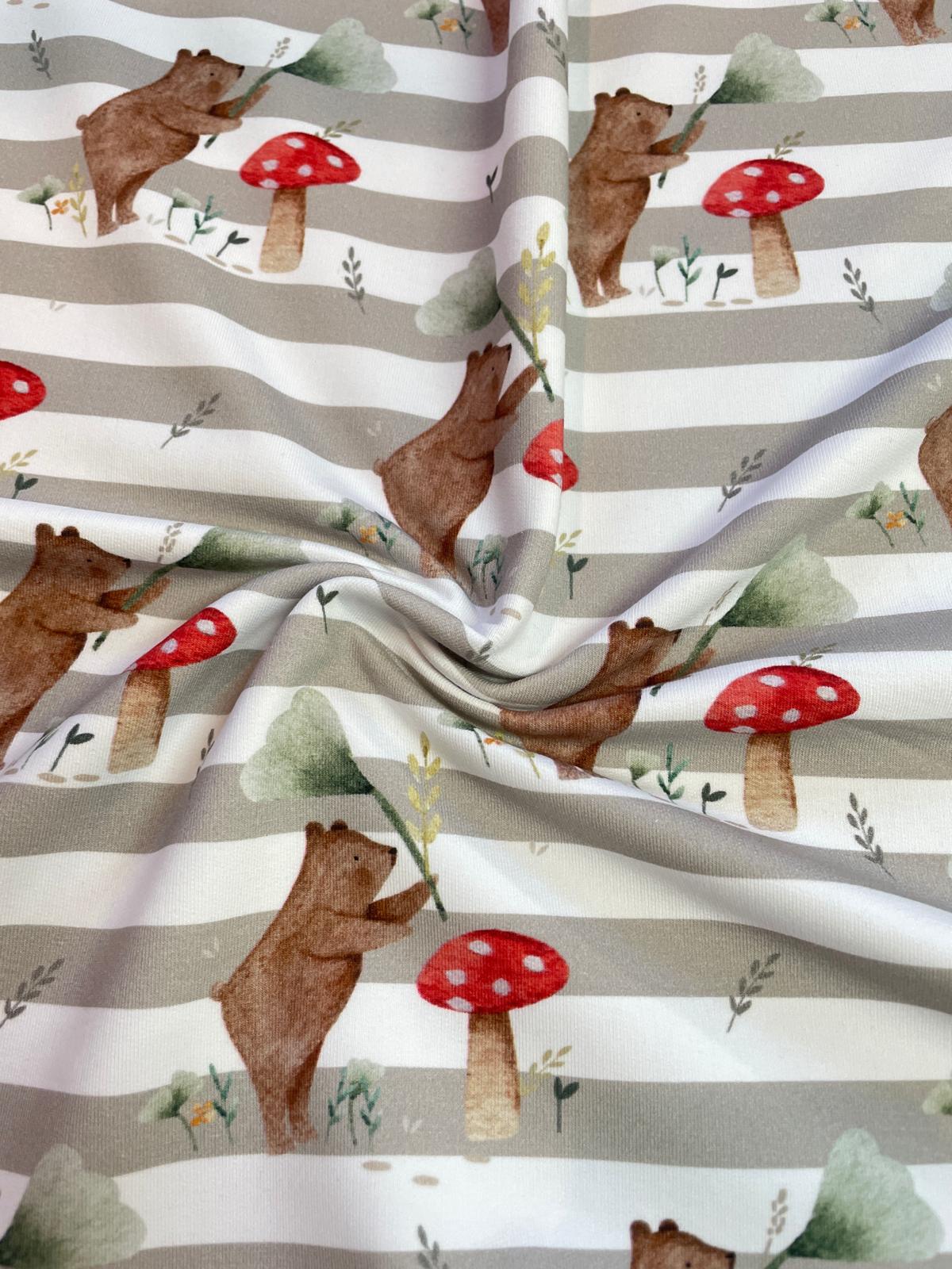 Bio French Terry Sommersweat als Meterware mit gestreiftem Hintergrund in Beige-Weiß und einem süßen Aquarell-Muster aus kleinen Bären und roten Fliegenpilzen.