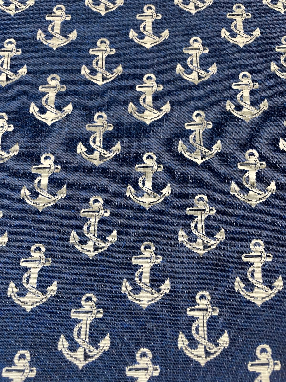 Gewebter Deko-Gobelinstoff als Meterware mit hellen, eingewebten Ankern auf einem kräftigen dunkelblauen Jacquard-Hintergrund.